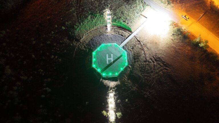 Vista aérea nocturna de un helipuerto con balizamiento iluminado
